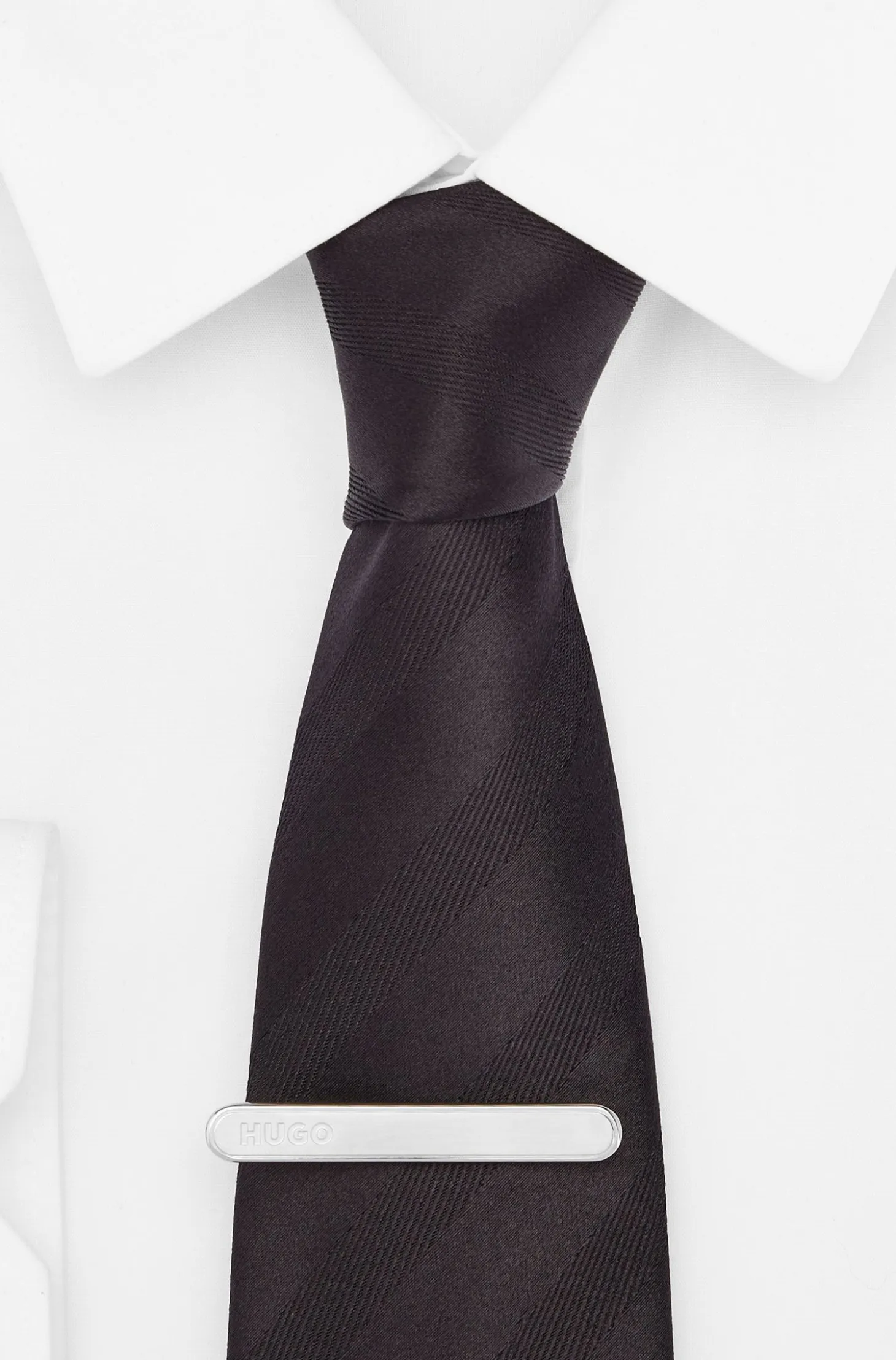Oval-shaped tie clip with engraved logo