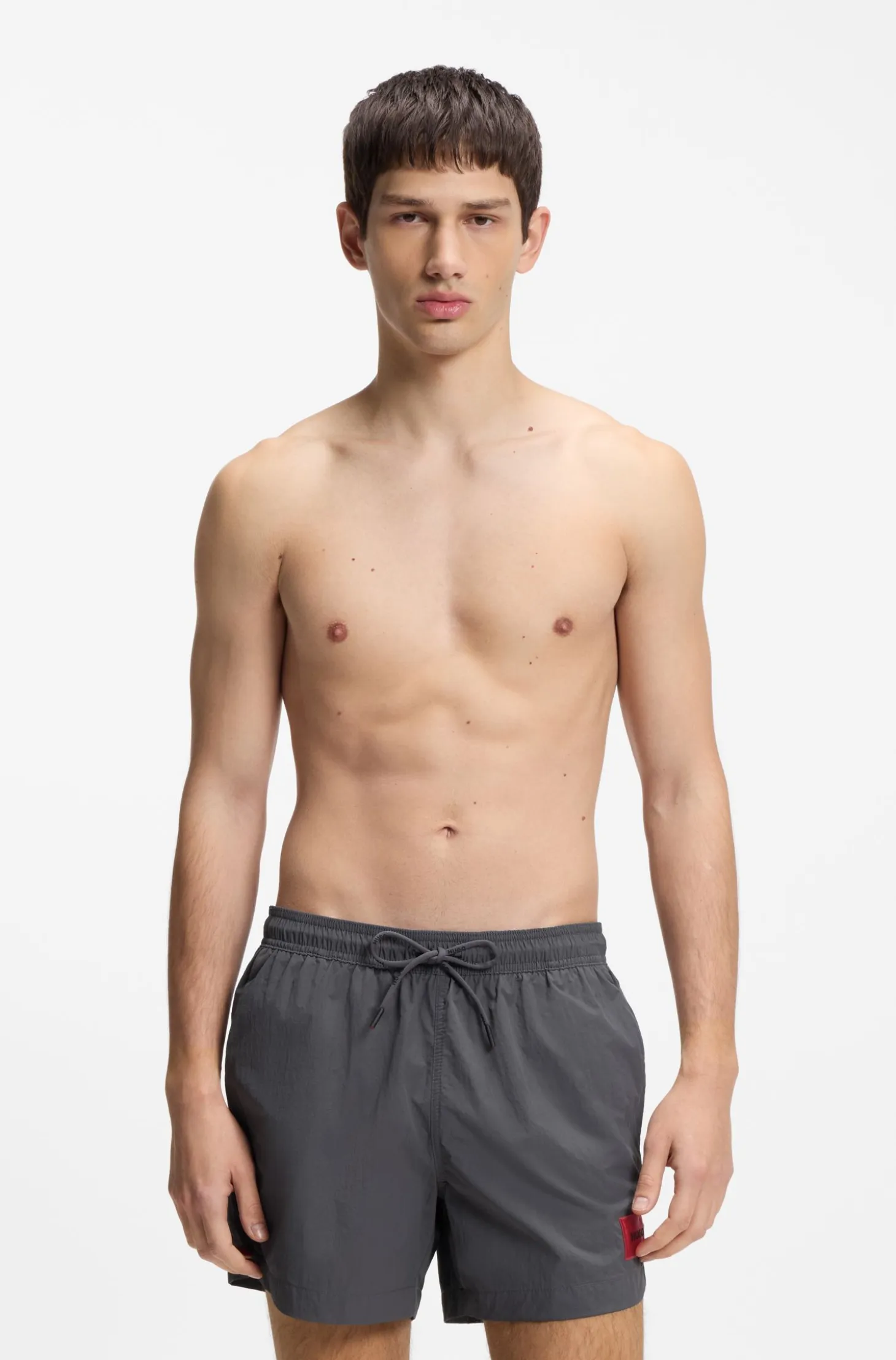 Quick-drying swim shorts with red logo label