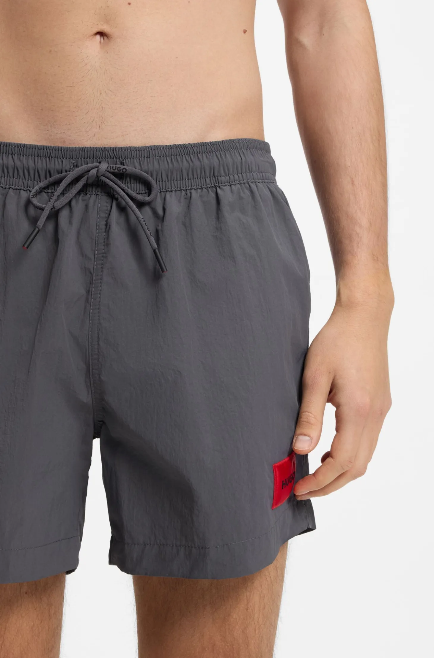 Quick-drying swim shorts with red logo label