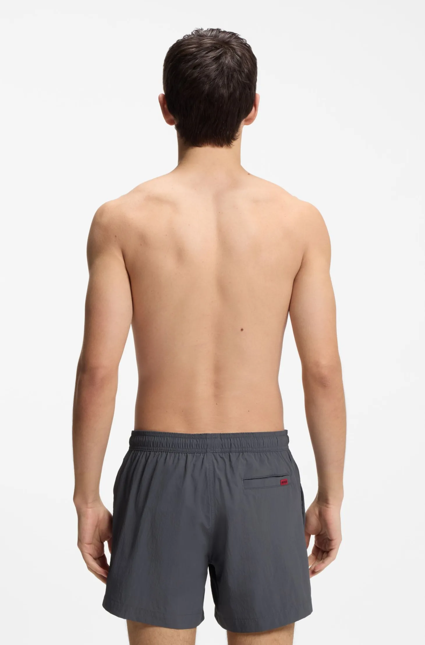 Quick-drying swim shorts with red logo label