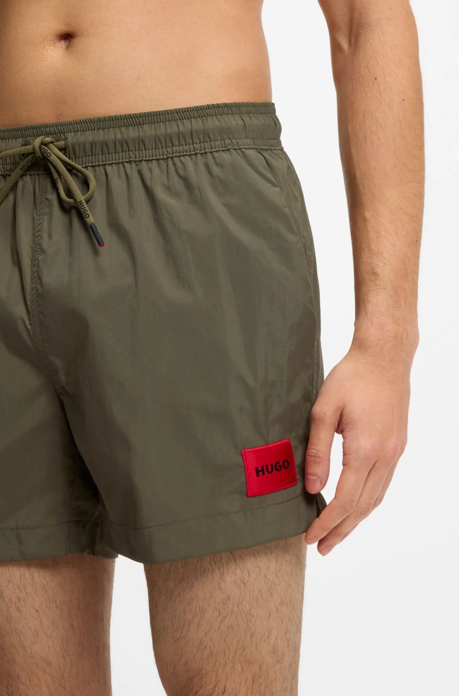 Quick-drying swim shorts with red logo label