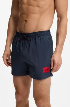 Quick-drying swim shorts with red logo label