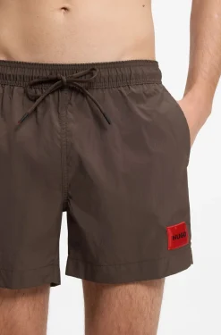 Quick-drying swim shorts with red logo label