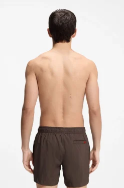 Quick-drying swim shorts with red logo label